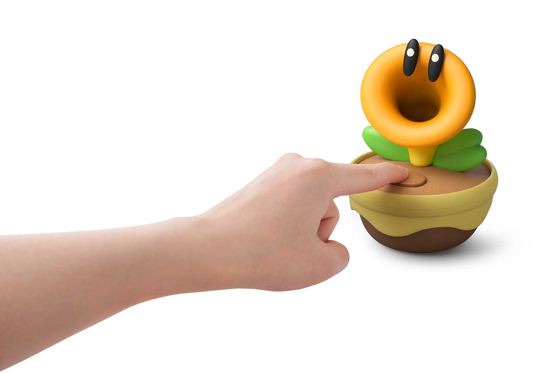 Eine Hand drückt auf eine braune Taste neben einer gelben Pflanze mit Augen.