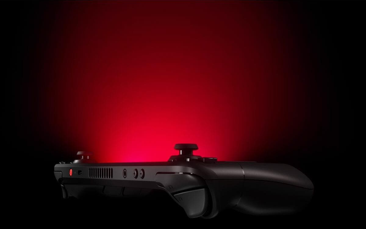 Une manette de jeu noire avec des accents rouges, éclairée sur fond sombre.
