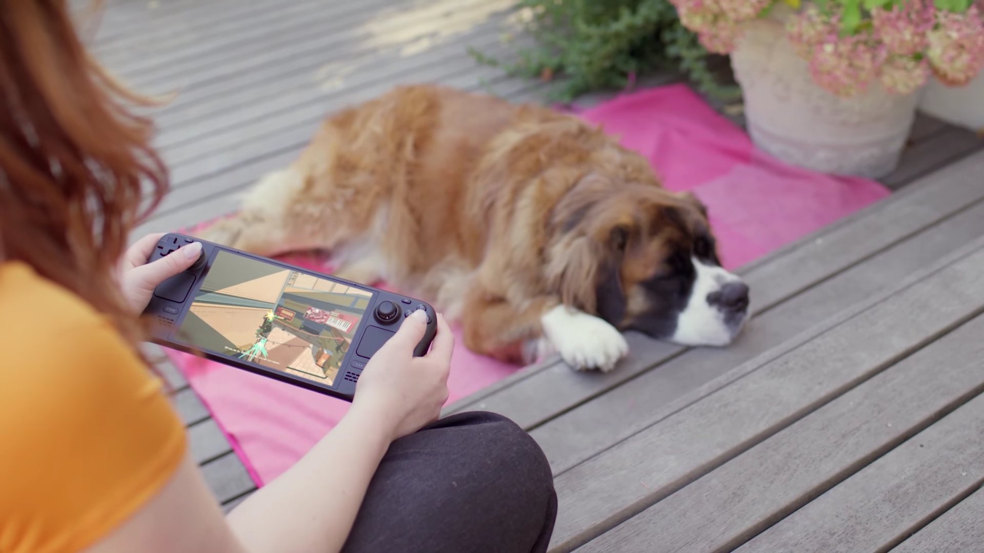 Une personne joue sur un appareil portable avec un chien qui se repose à proximité.