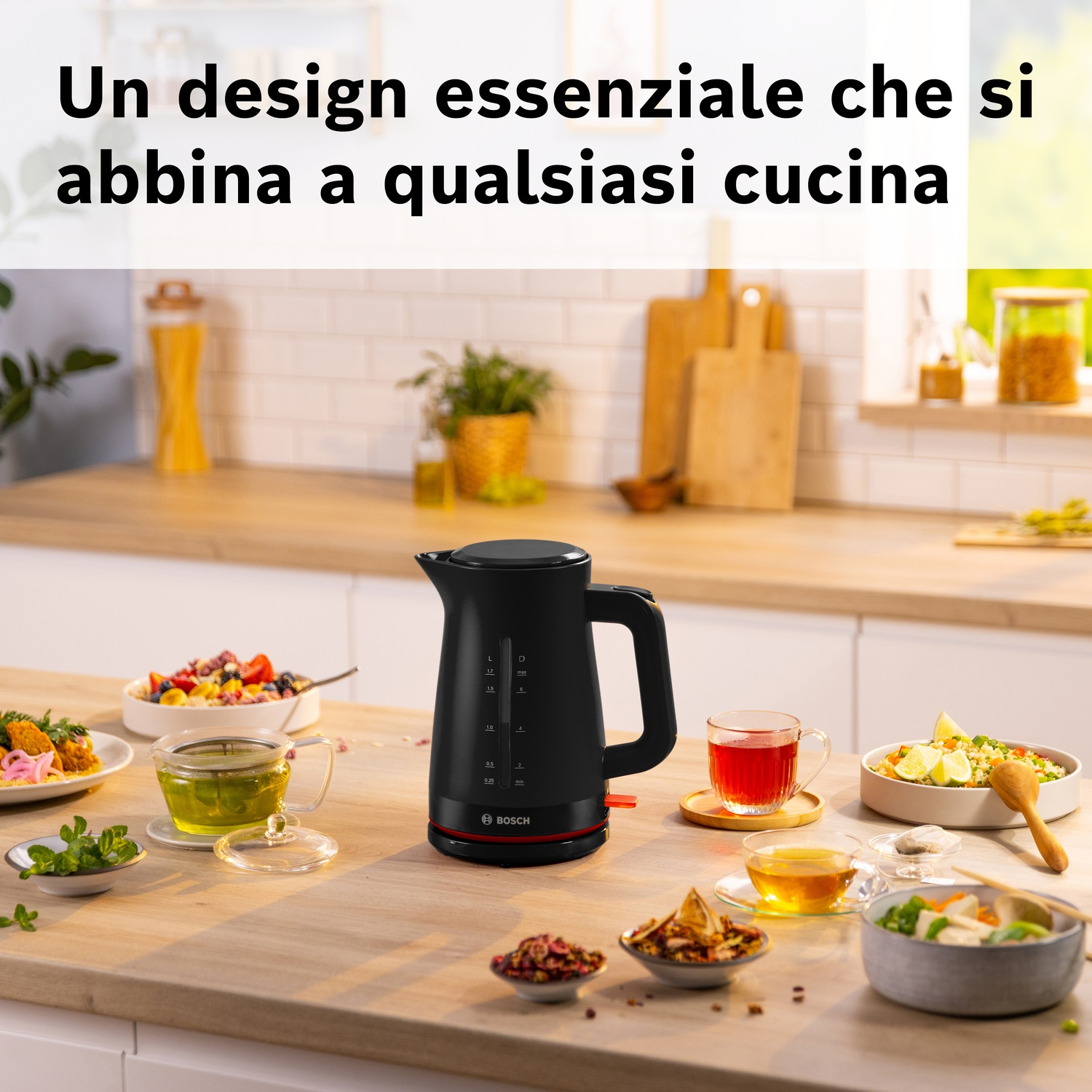 Bollitore nero con dettagli rossi su tavolo in legno con cibo e bevande.