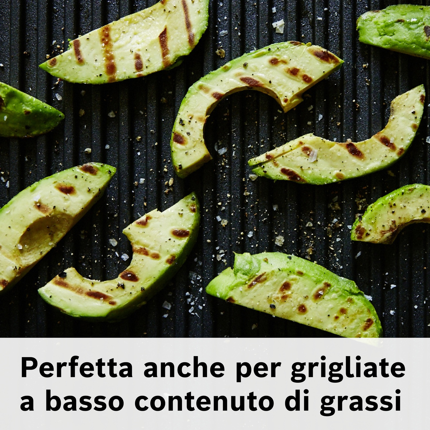 Fette di avocado grigliate con condimento su una superficie scura e rigata. Testo in italiano: "Perfetta anche per grigliate a basso contenuto di grassi"
