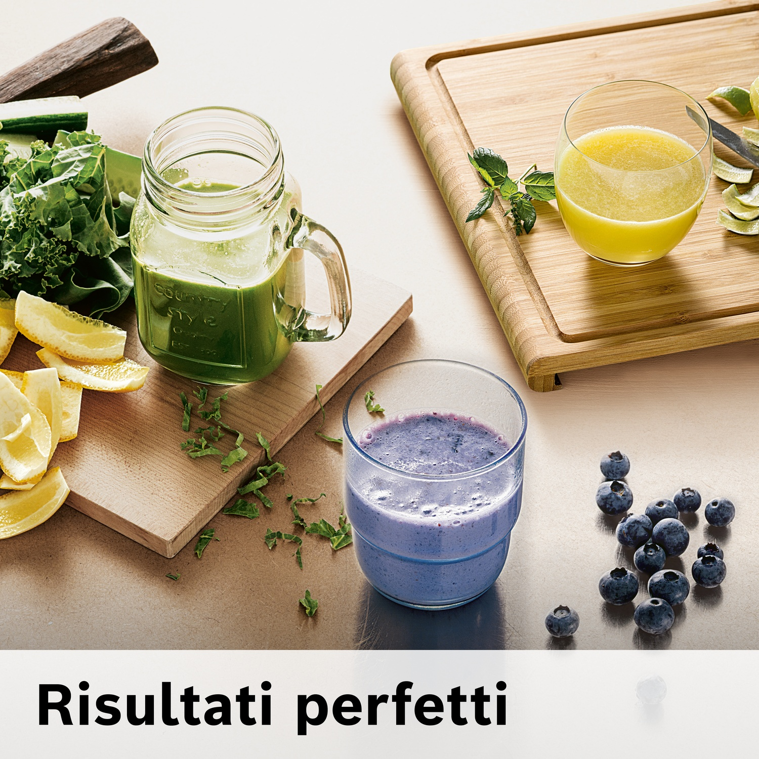 Frullati verdi e blu con bacche, limoni ed erbe su taglieri di legno.