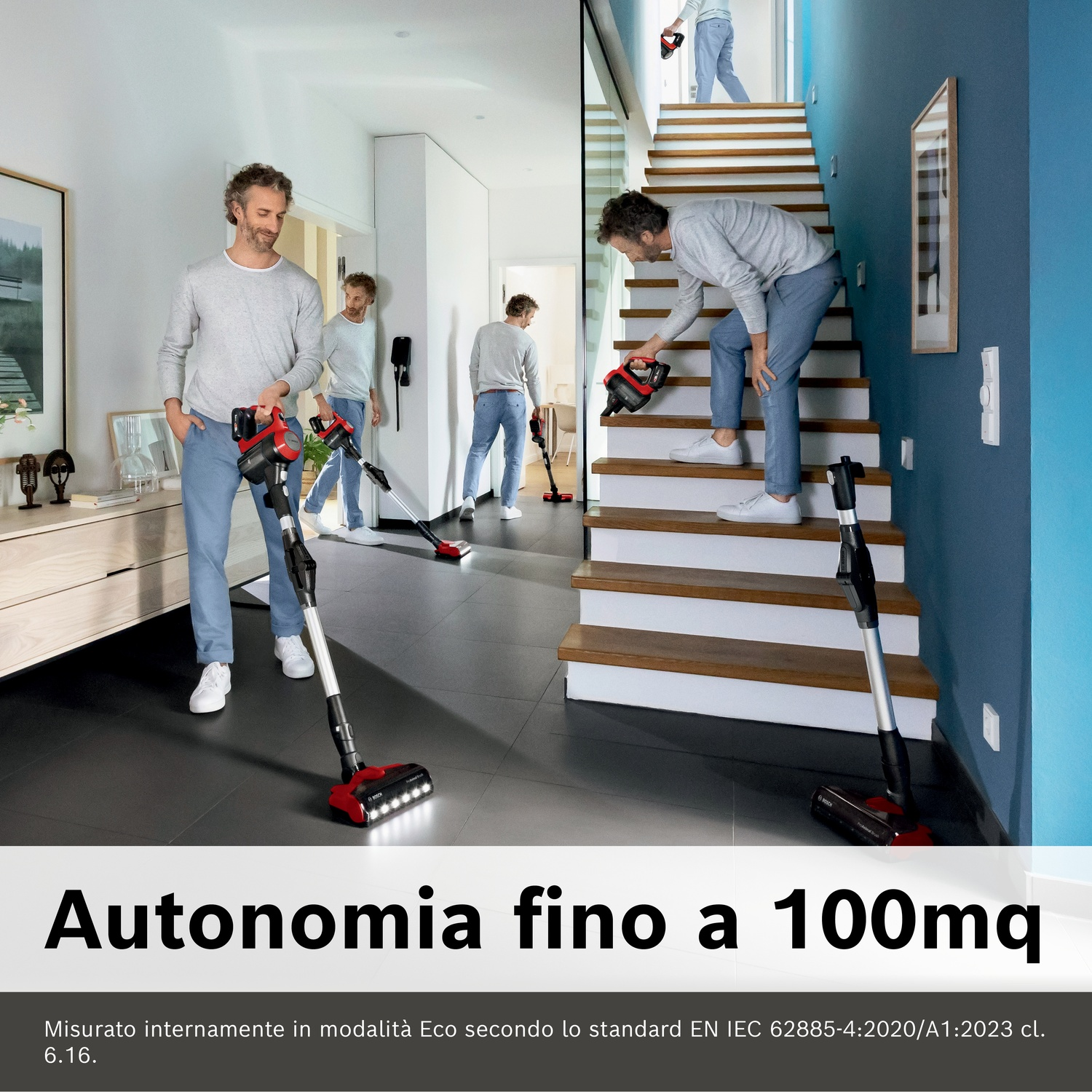 Uomo aspira in casa e sulle scale con aspirapolvere rosso.