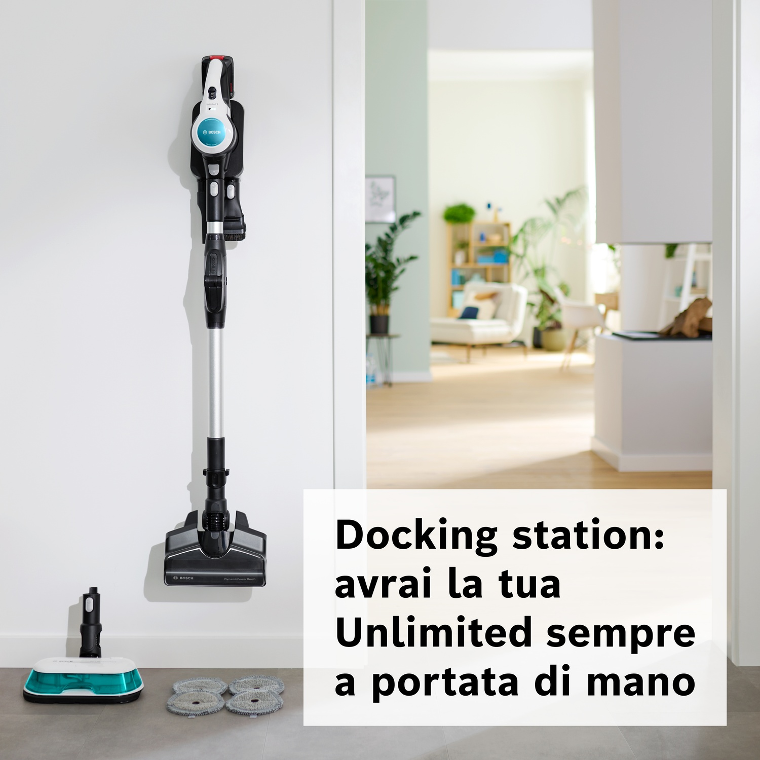Un aspirapolvere senza fili Bosch è appeso a una staffa a muro con accessori vicini.