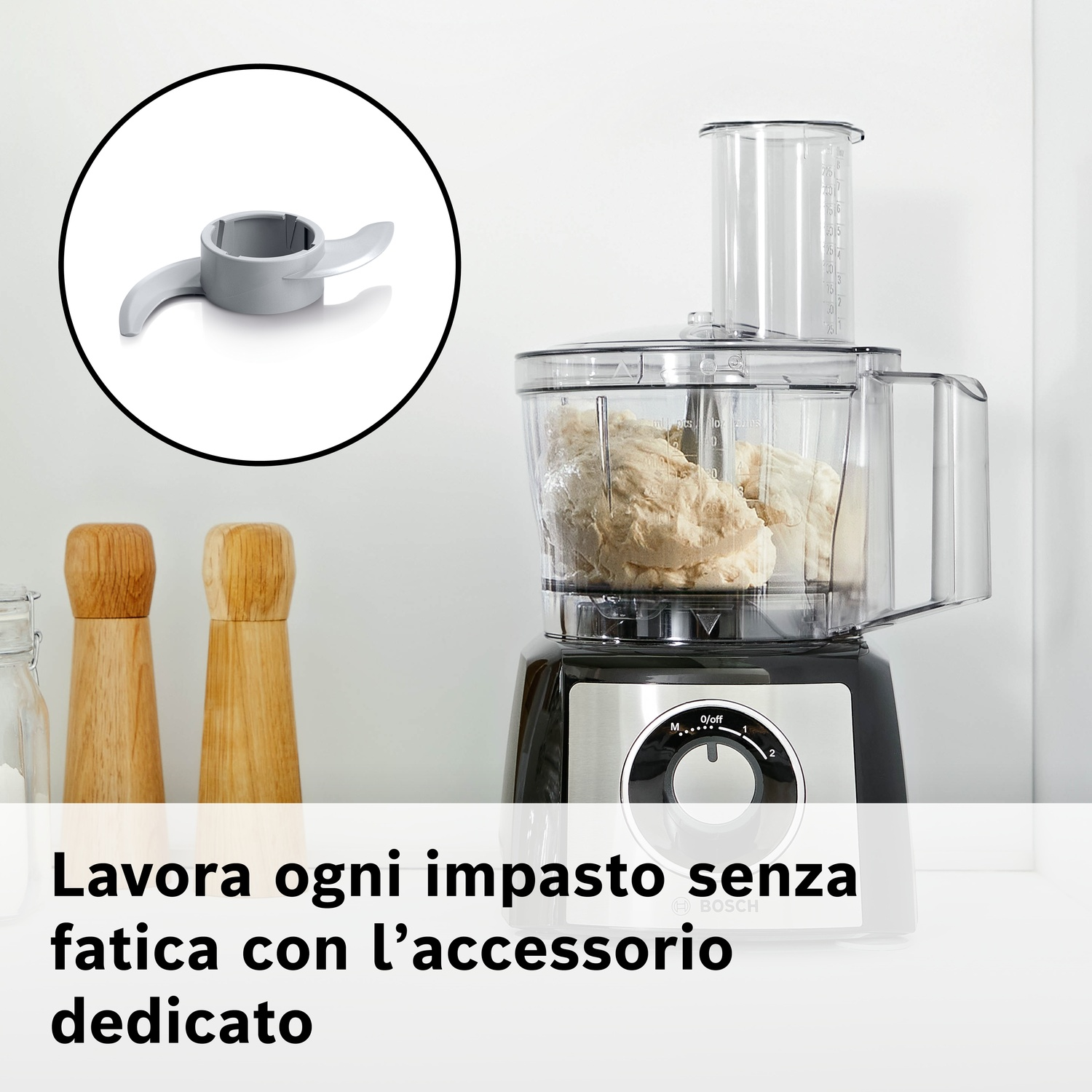 Accessorio mixer grigio con due lame vicino a un robot da cucina con impasto.