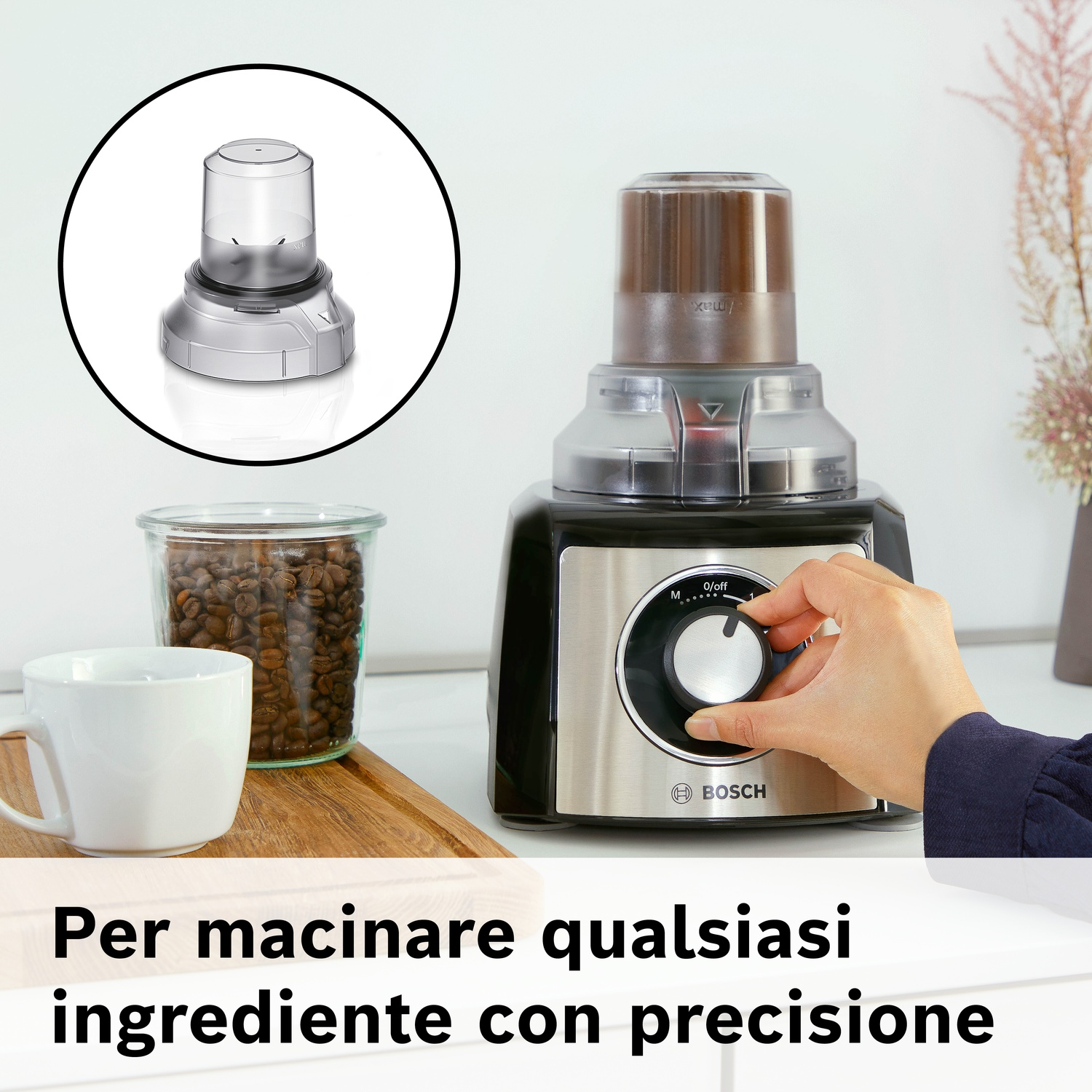 Robot da cucina con accessori: chicchi di caffè, tazza e macina. Mano gira selettore.