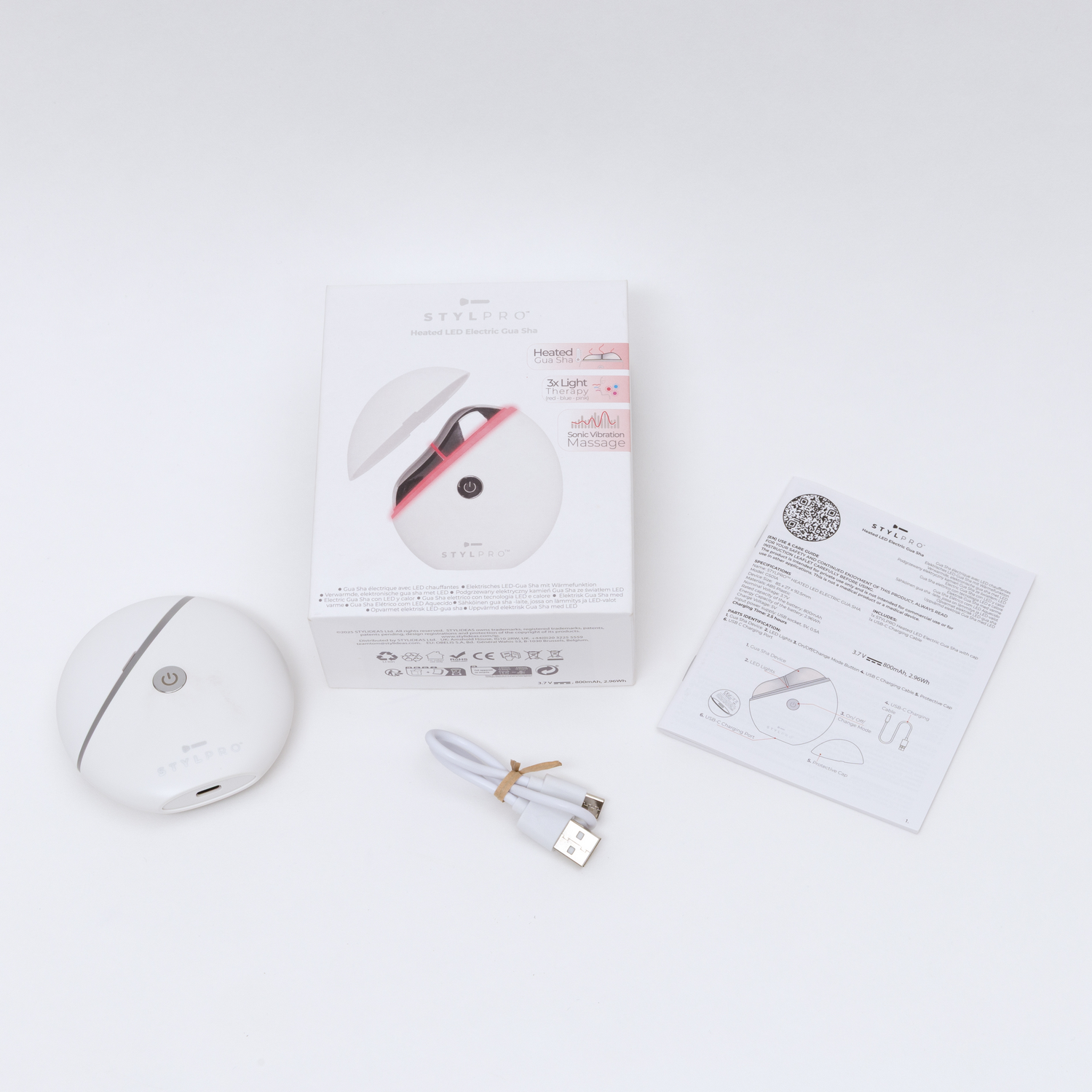 Un dispositivo blanco eléctrico Gua Sha con cable y manual.