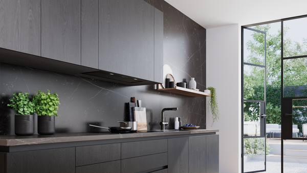 Mermer tezgah arası ve bahçeye açılan cam kapılı modern koyu mutfak.