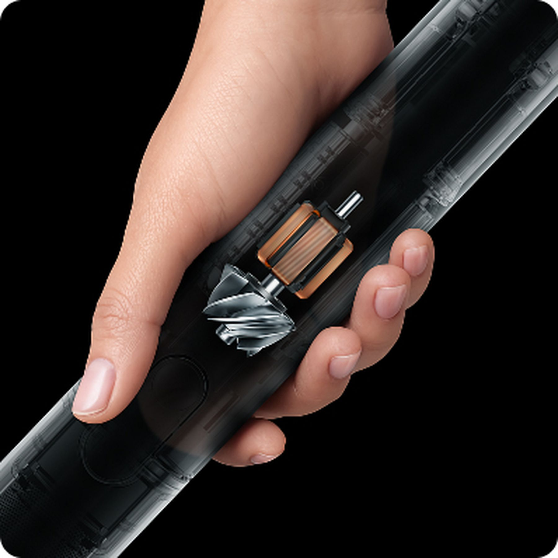 Dłoń trzyma przezroczyste urządzenie, ukazując mosiężny silnik i srebrny wirnik.