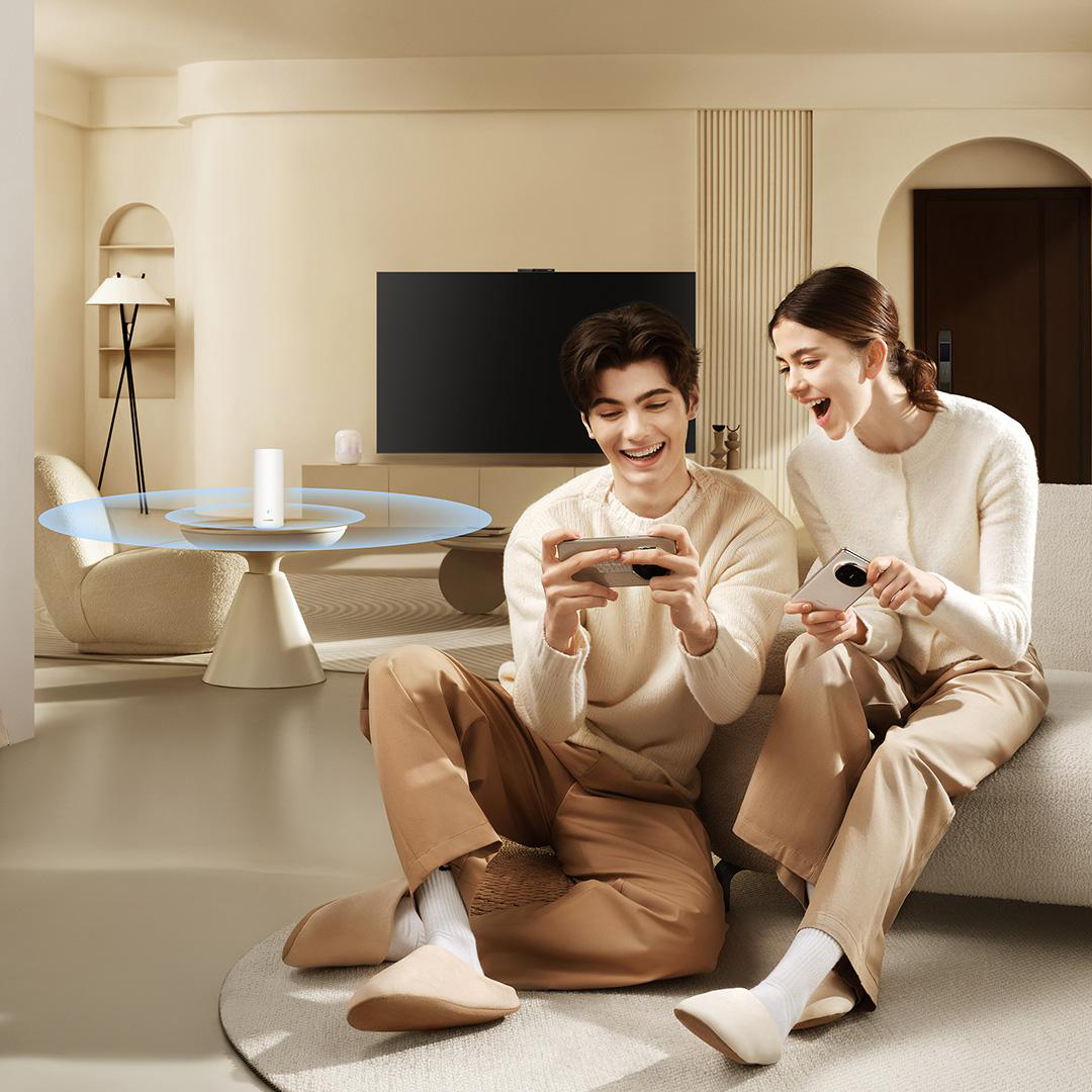 Ein Paar spielt auf Smartphones in einem gemütlichen Wohnzimmer. Ein Router steht auf einem Tisch.