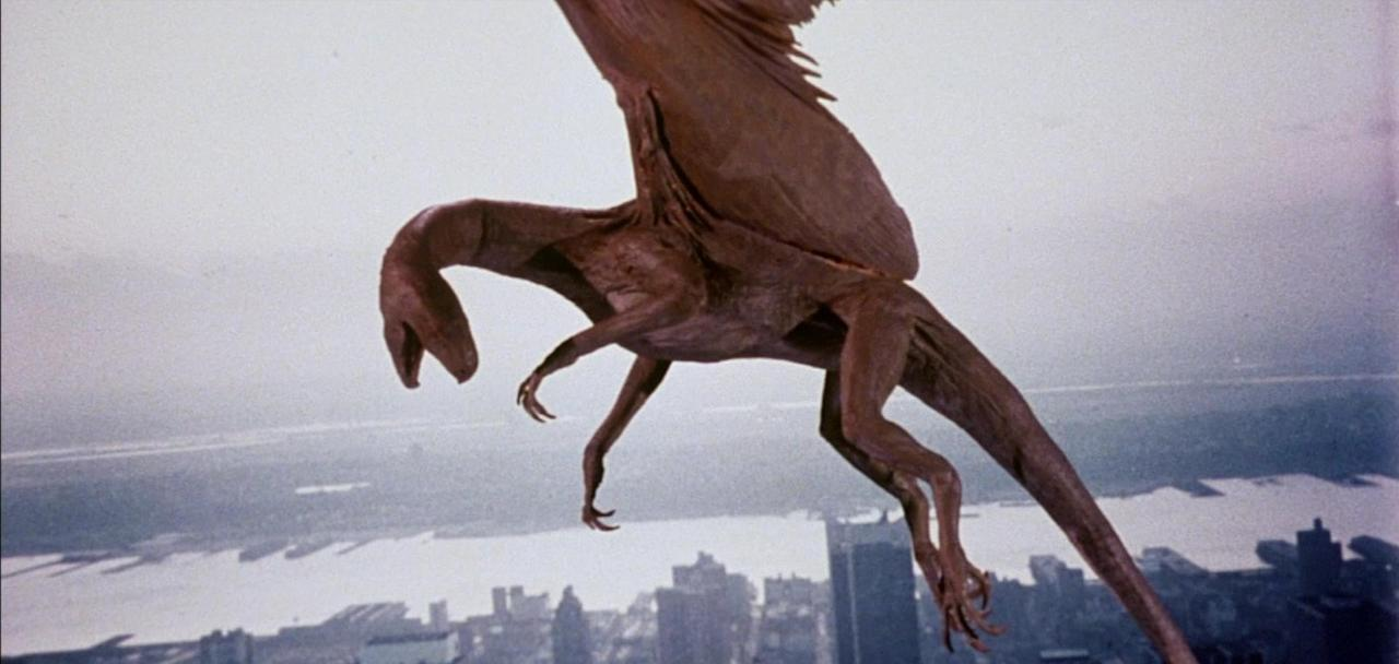 Ein braunes Flugreptil fliegt über einer Stadt und einem Gewässer.