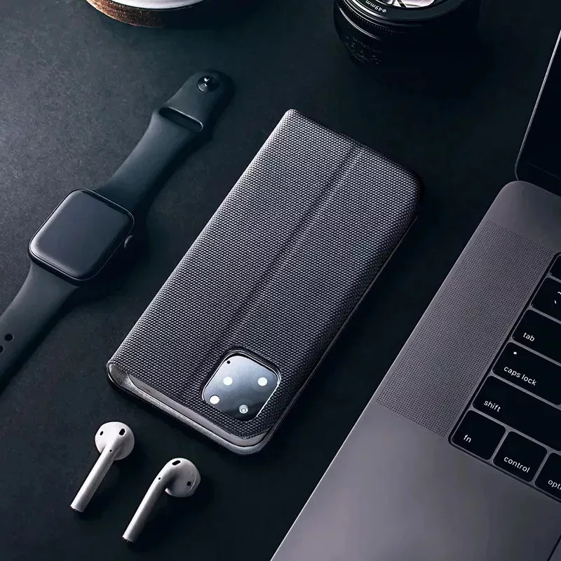 Fekete okostelefon tokkal, Apple Watch-csal, AirPodsszal és laptop.