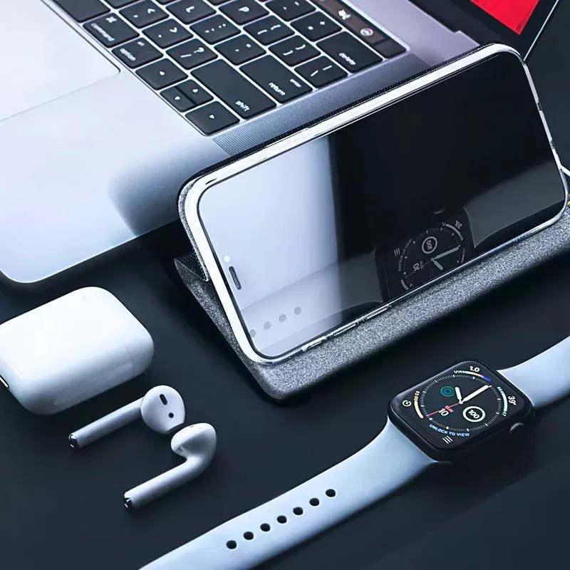 Laptop, okostelefon, AirPods és okosóra egymás mellett.