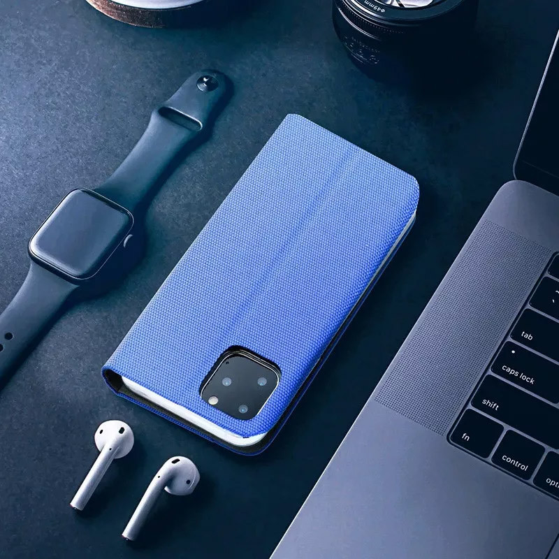 Kék telefontok, AirPods, Apple Watch és laptop sötét felületen.