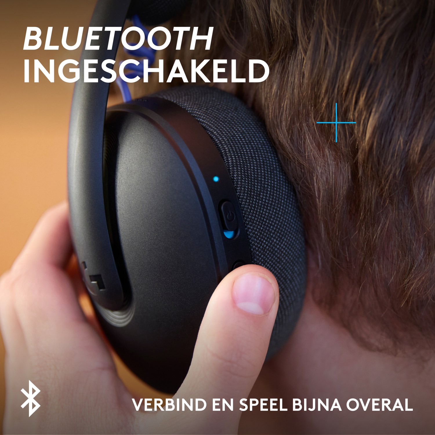 Close-up van zwarte koptelefoon met blauwe accenten, vastgehouden door een hand.