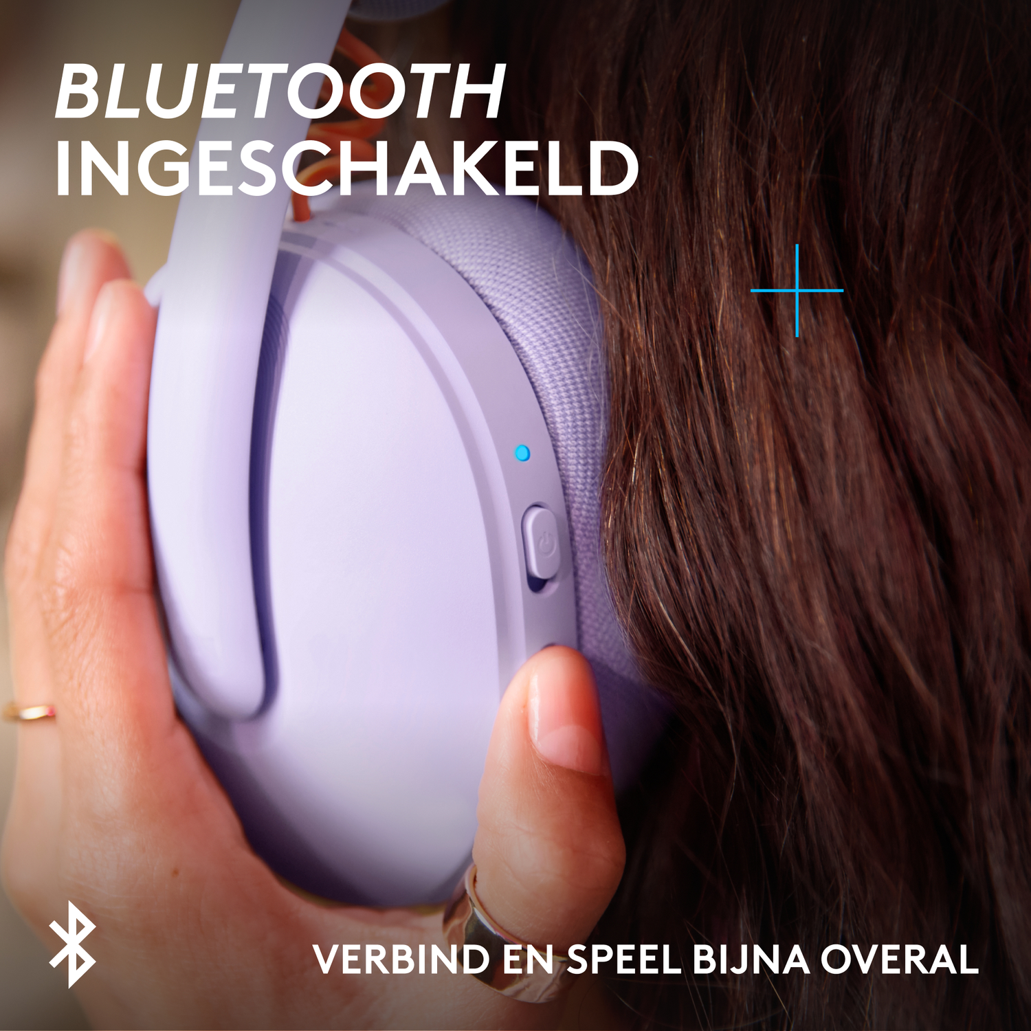 Purple headphones with Bluetooth symbol and text. A hand holds them.