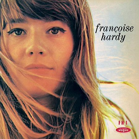 Portret van Françoise Hardy, haar in de wind, lichte lucht, tekst rechtsboven.