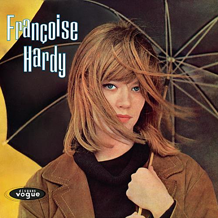 Françoise Hardy met paraplu, bruine jas, zwarte coltrui.