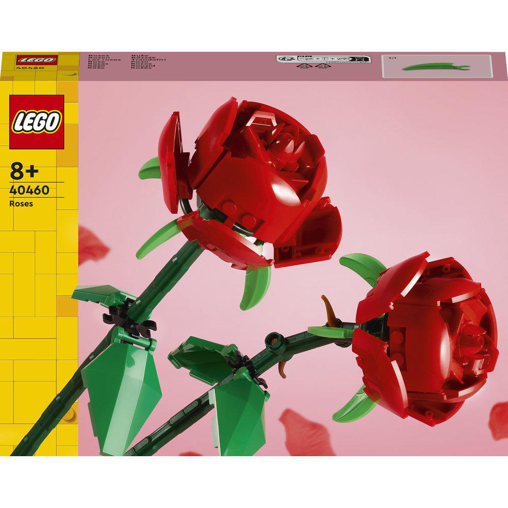 Zwei rote Lego-Rosen mit grünen Blättern und Stielen auf rosa Hintergrund.