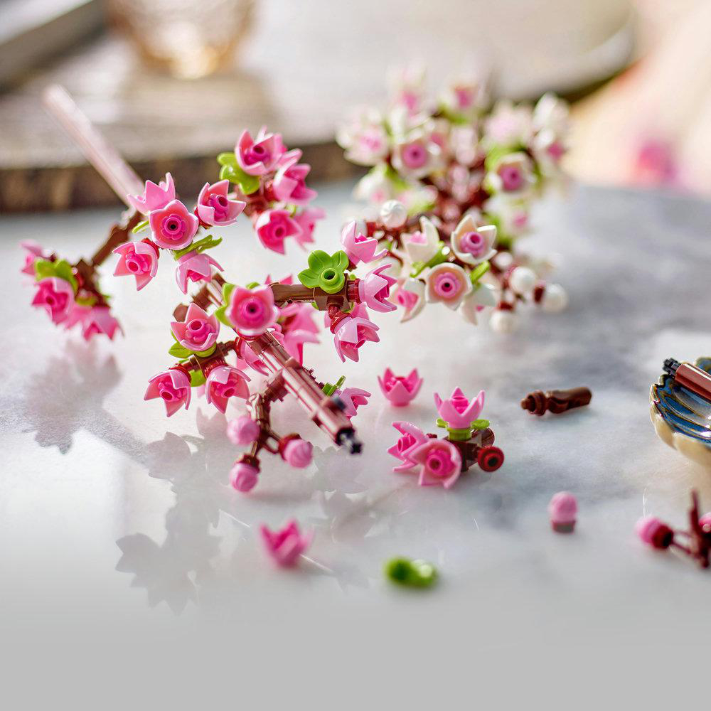 Miniatur-Kirschblüten auf einem Marmortisch, einige verstreut.