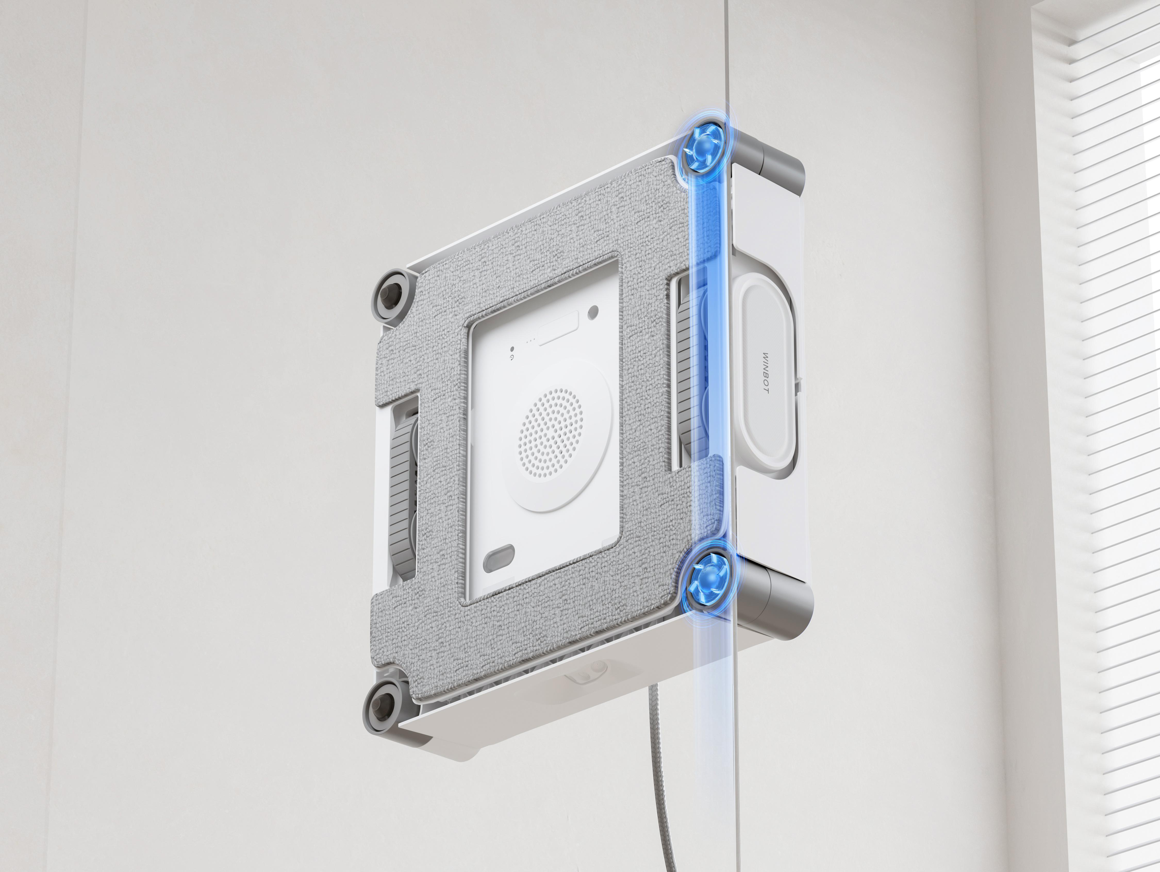 Ein weißer Roboter reinigt ein Fenster. Blaue Luftströme zeigen die Saugkraft.