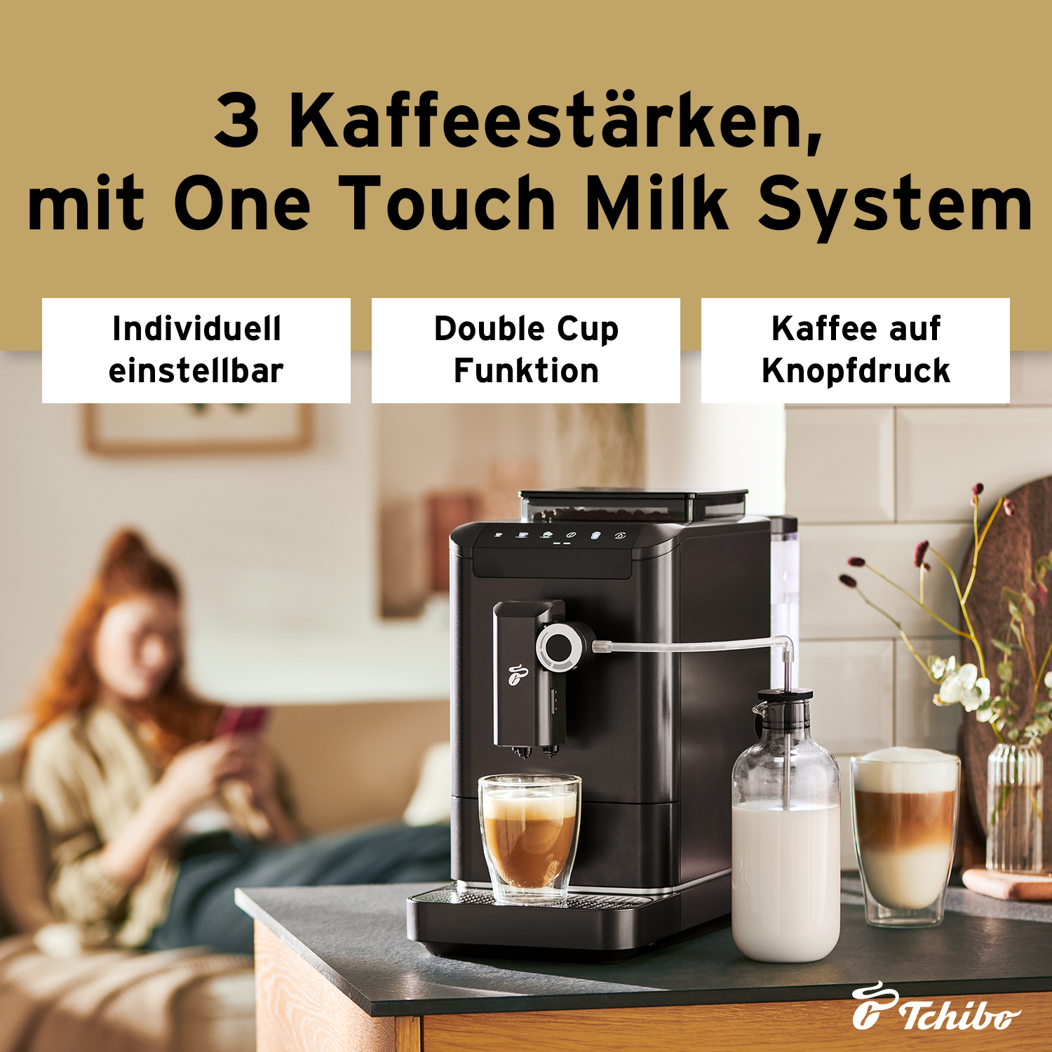 Eine schwarze Kaffeemaschine mit Milchkännchen und zwei Kaffees auf einer Theke. Text: 3 Kaffeestärken, mit One Touch Milk System.
