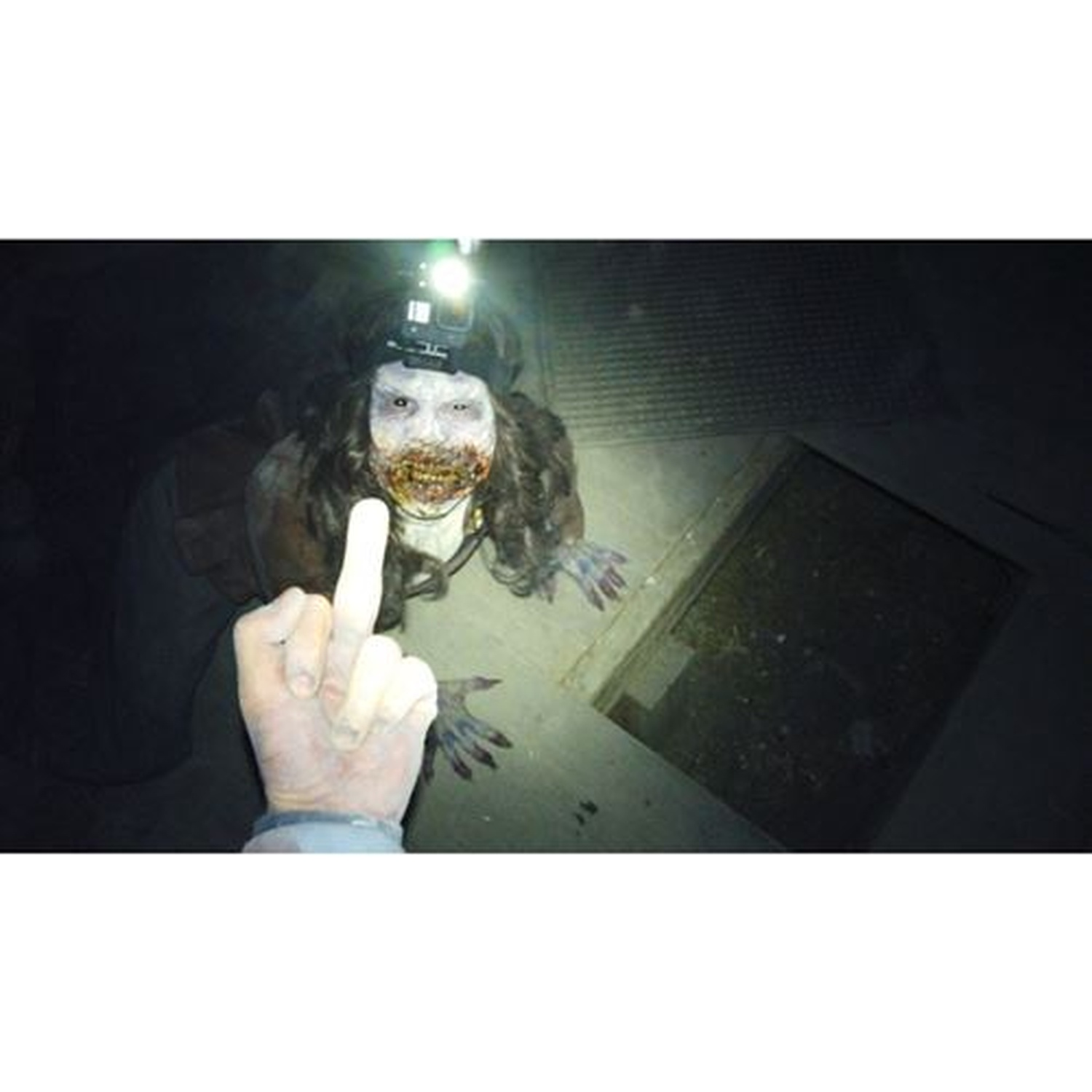 Een griezelig figuur met een GoPro op het hoofd schijnt licht in het donker.