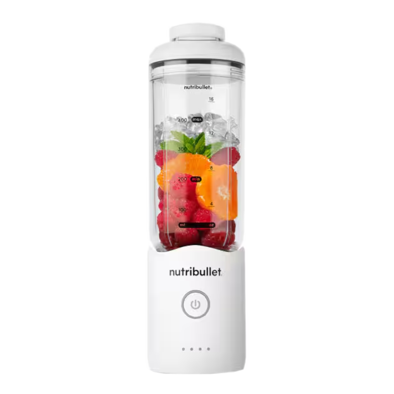 Un frullatore Nutribullet bianco con bacche, ghiaccio e fette d'arancia nel contenitore.