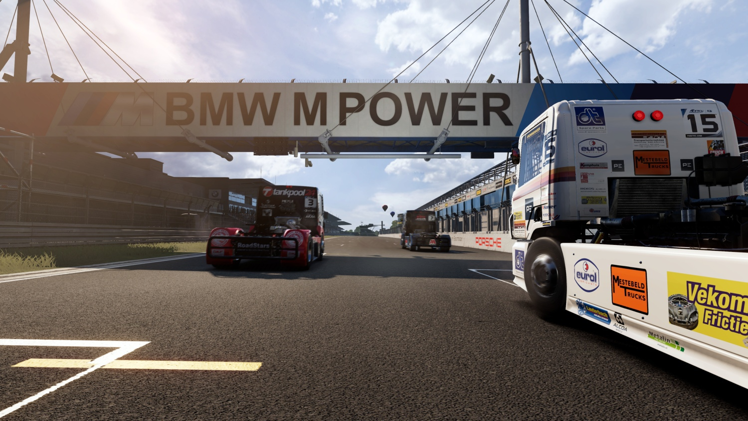 Pista da corsa con camion sotto il portale BMW M POWER. Camion bianco in primo piano.