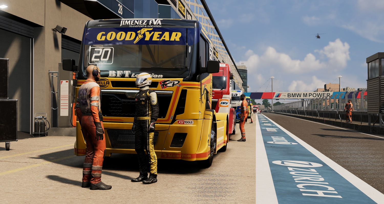 Corridori accanto a camion da corsa gialli e rossi su una pista con striscione BMW M POWER.