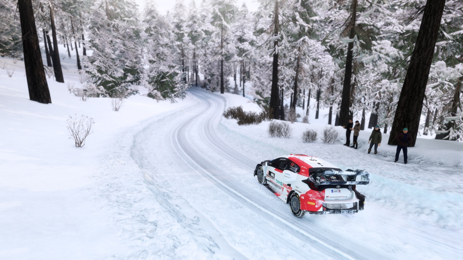 Ein weiß-rotes Rallyeauto fährt auf einer schneebedeckten Straße durch einen verschneiten Wald.