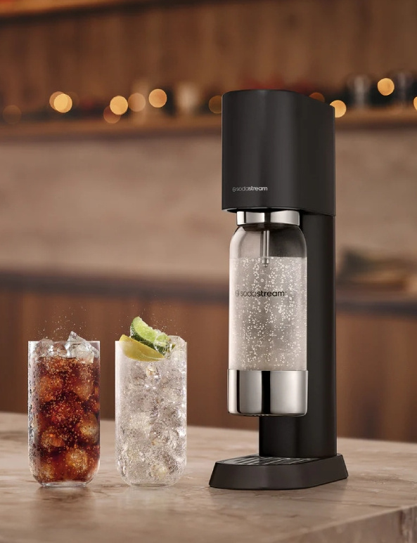 Czarny SodaStream obok dwóch szklanek wypełnionych lodem i napojami.