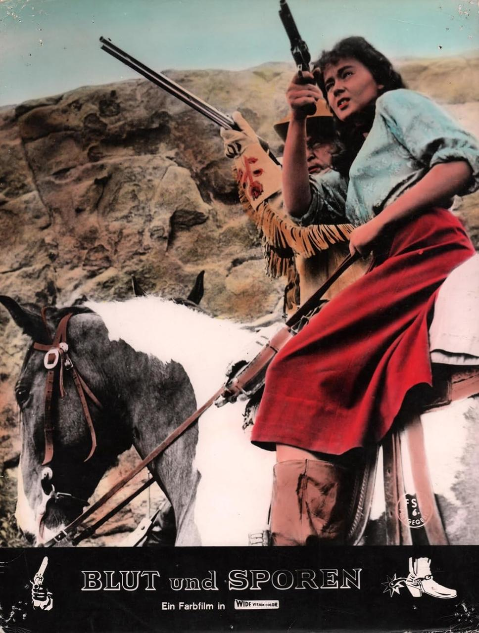 Eine Frau und ein Mann auf einem Pferd schießen mit Gewehren in einer felsigen Landschaft.