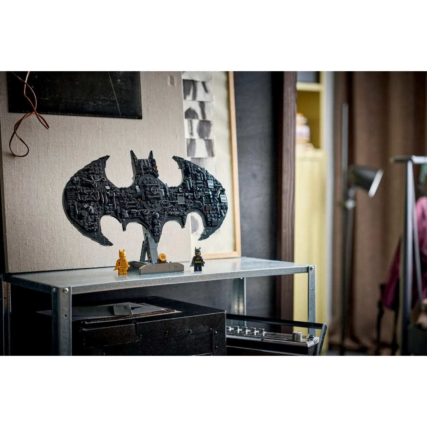 Logo di Batman in LEGO con due minifigure su uno scaffale.