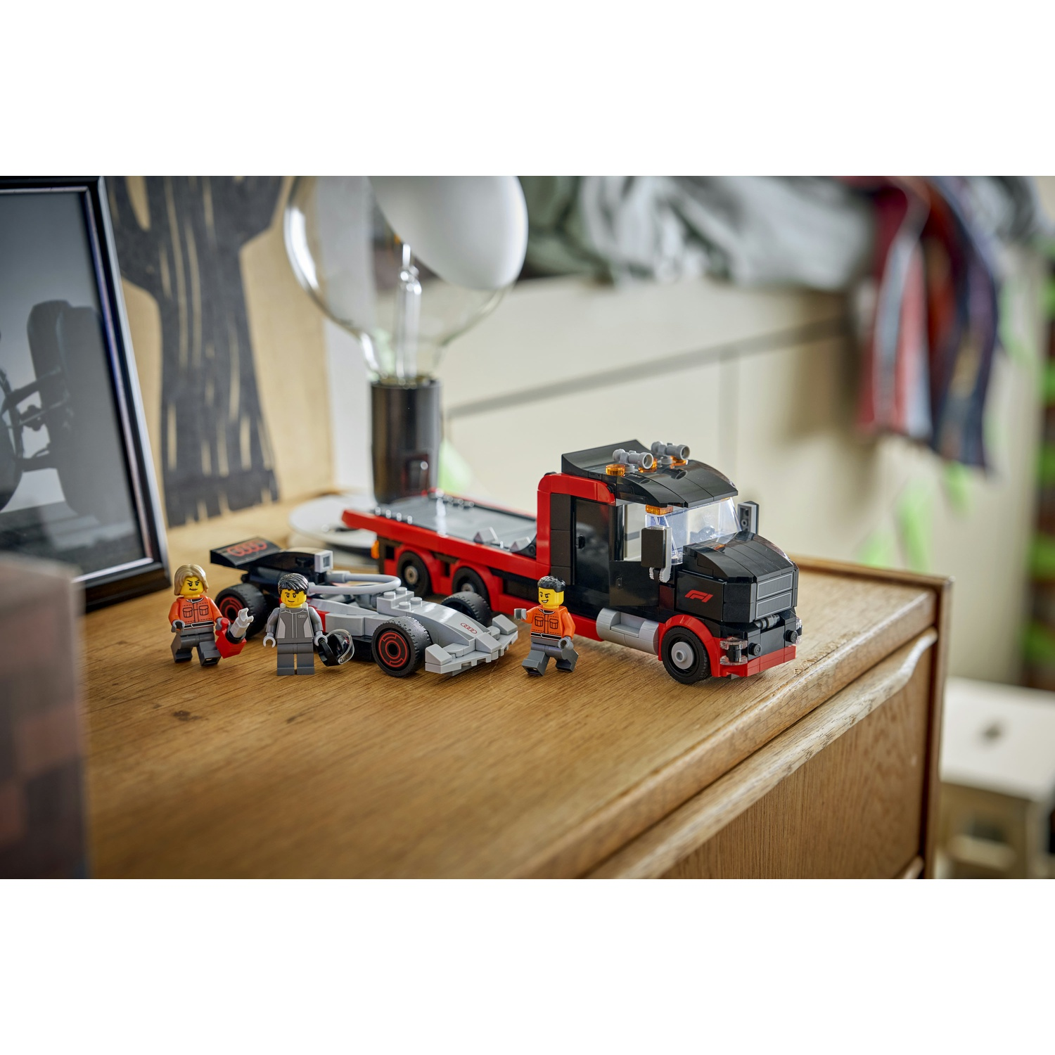 Una macchina da corsa e un camion Lego con tre figure su una superficie di legno.