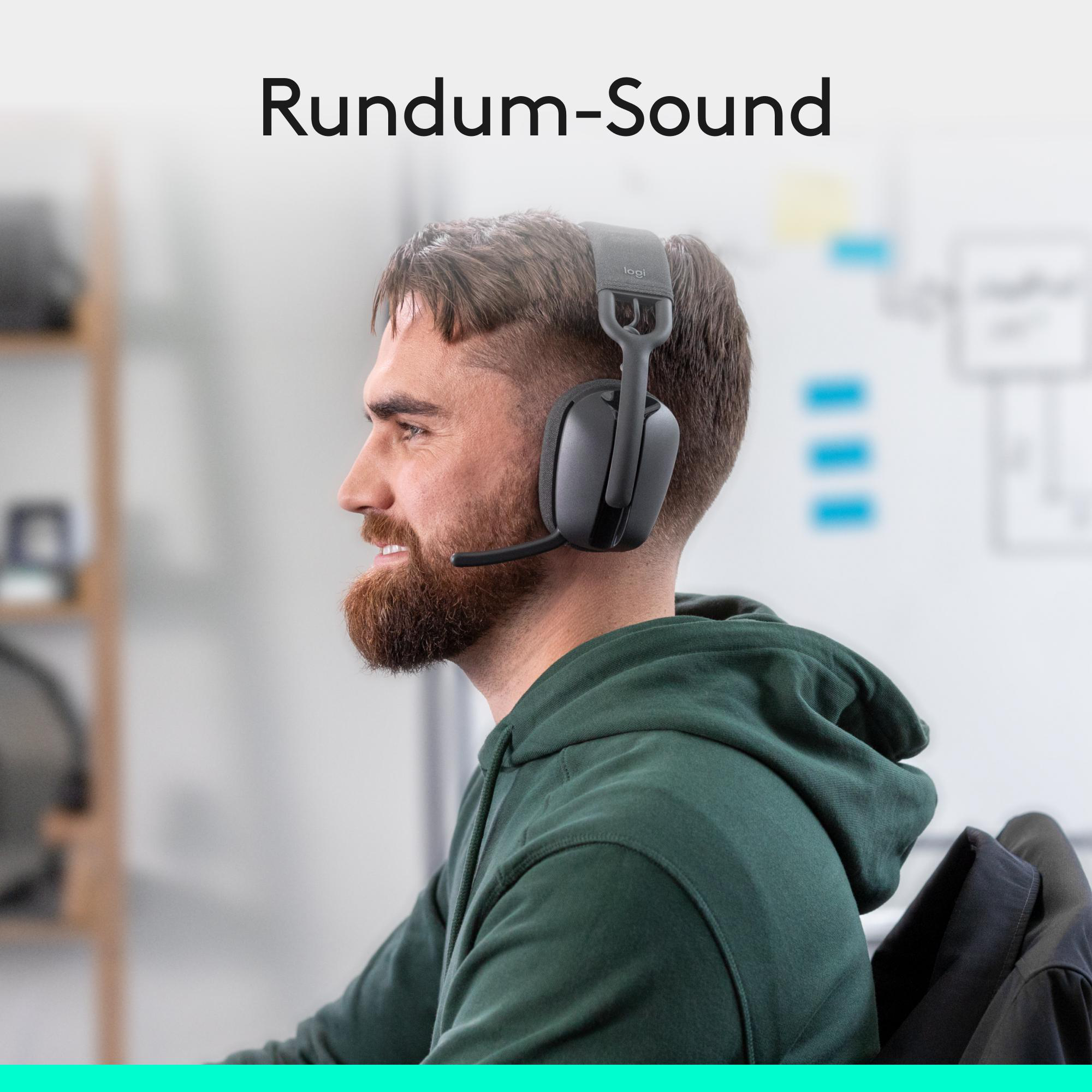 Mann mit Bart trägt Kopfhörer, sitzt am Schreibtisch. Rundum-Sound.