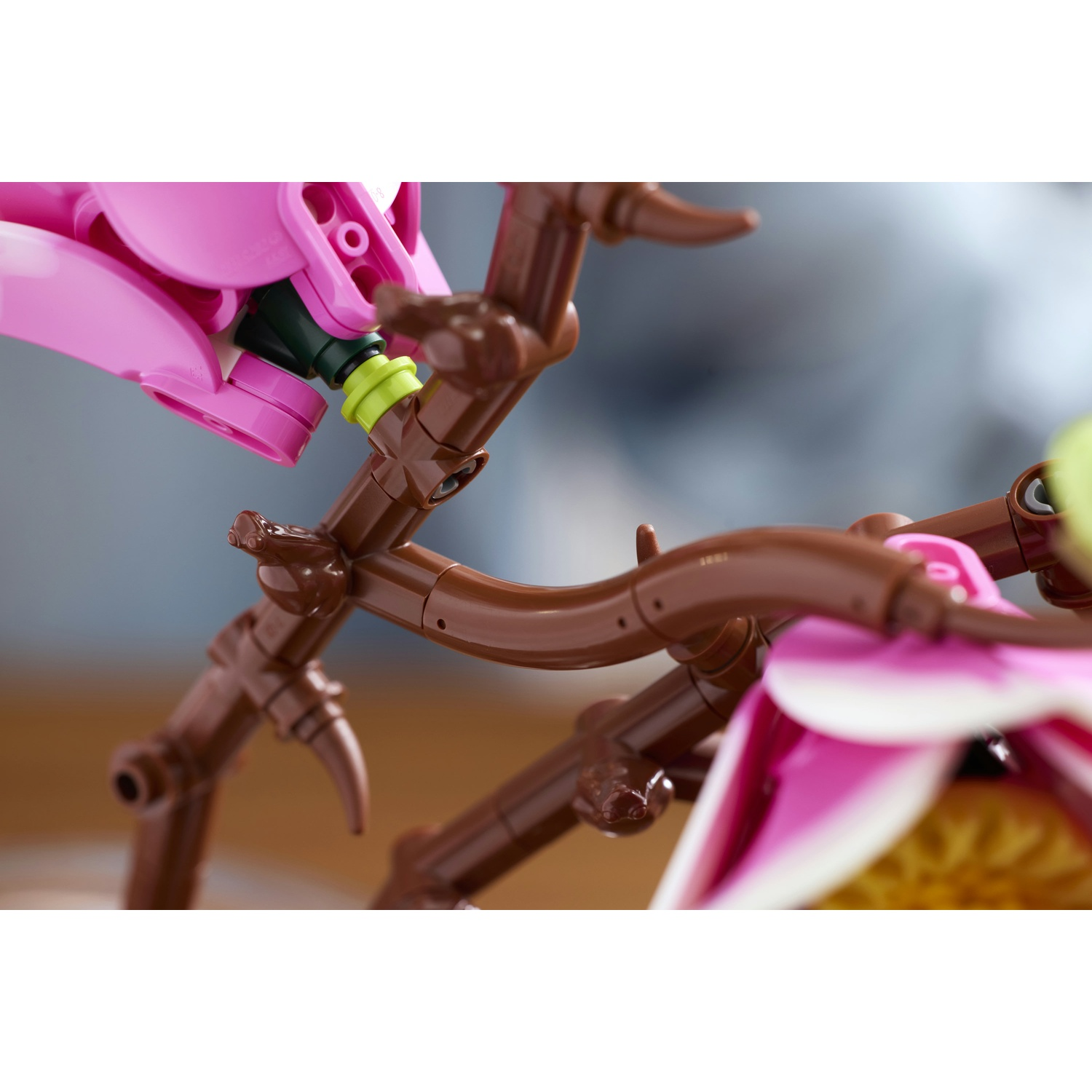 Costruzione di ramo Lego marrone con petali rosa e bianchi.