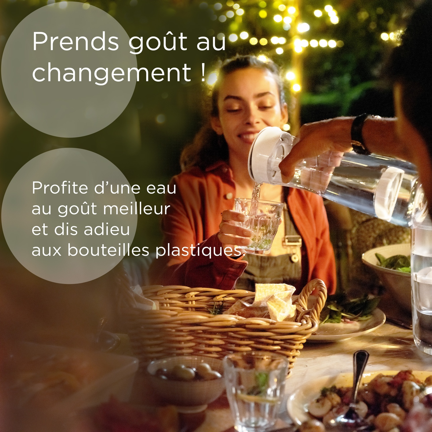 Een vrouw schenkt water uit een kan in een glas tijdens een diner buiten.