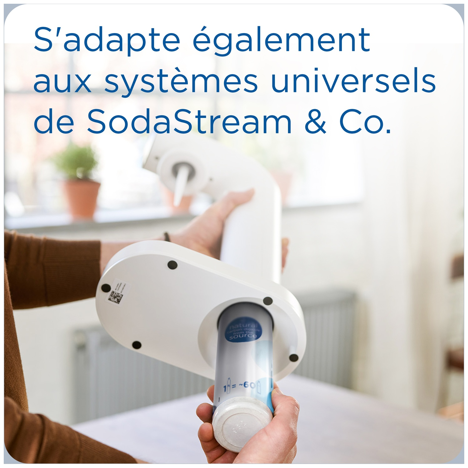 A white SodaStream adapter is inserted into a holder. A CO2 cylinder is visible.