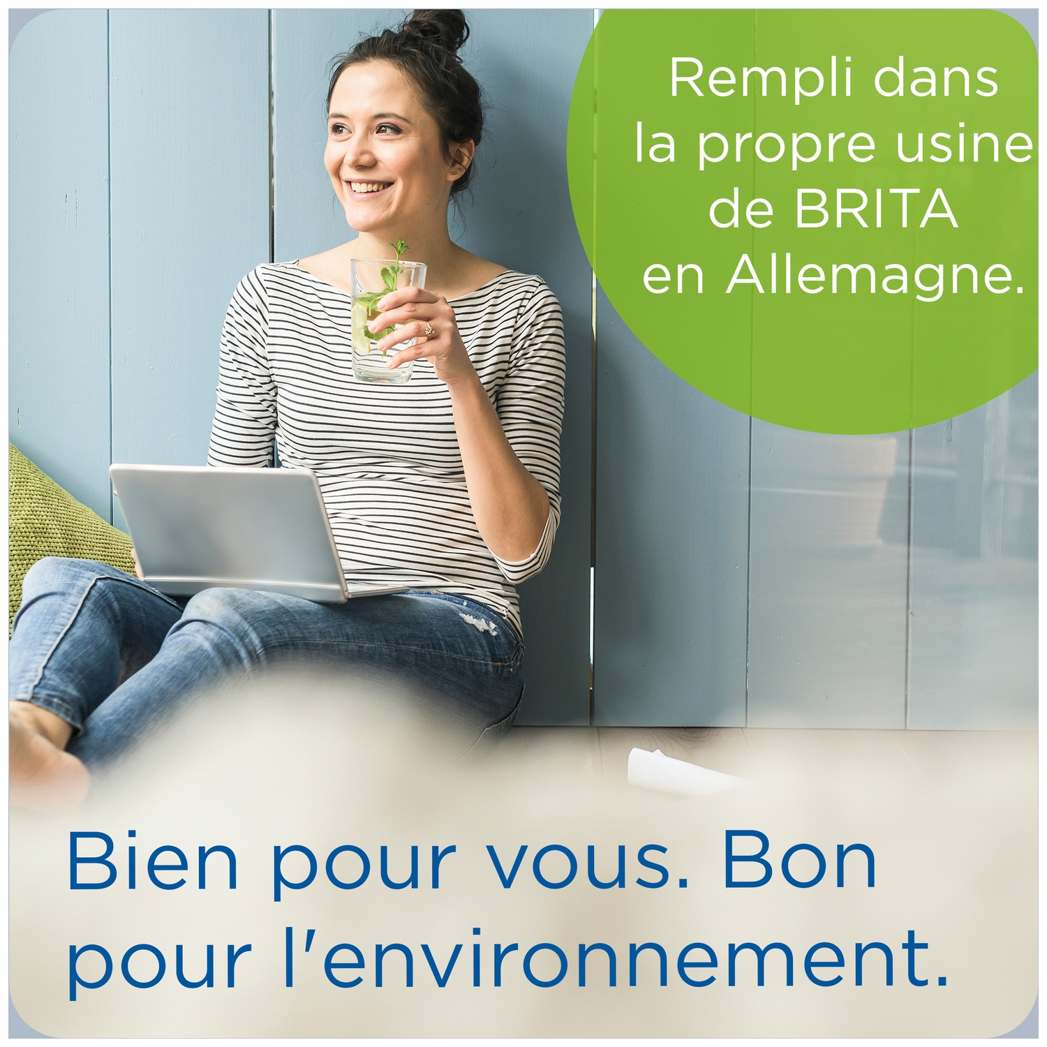 Woman drinks mint water, sits on floor with laptop. Made in Germany. Good for you.