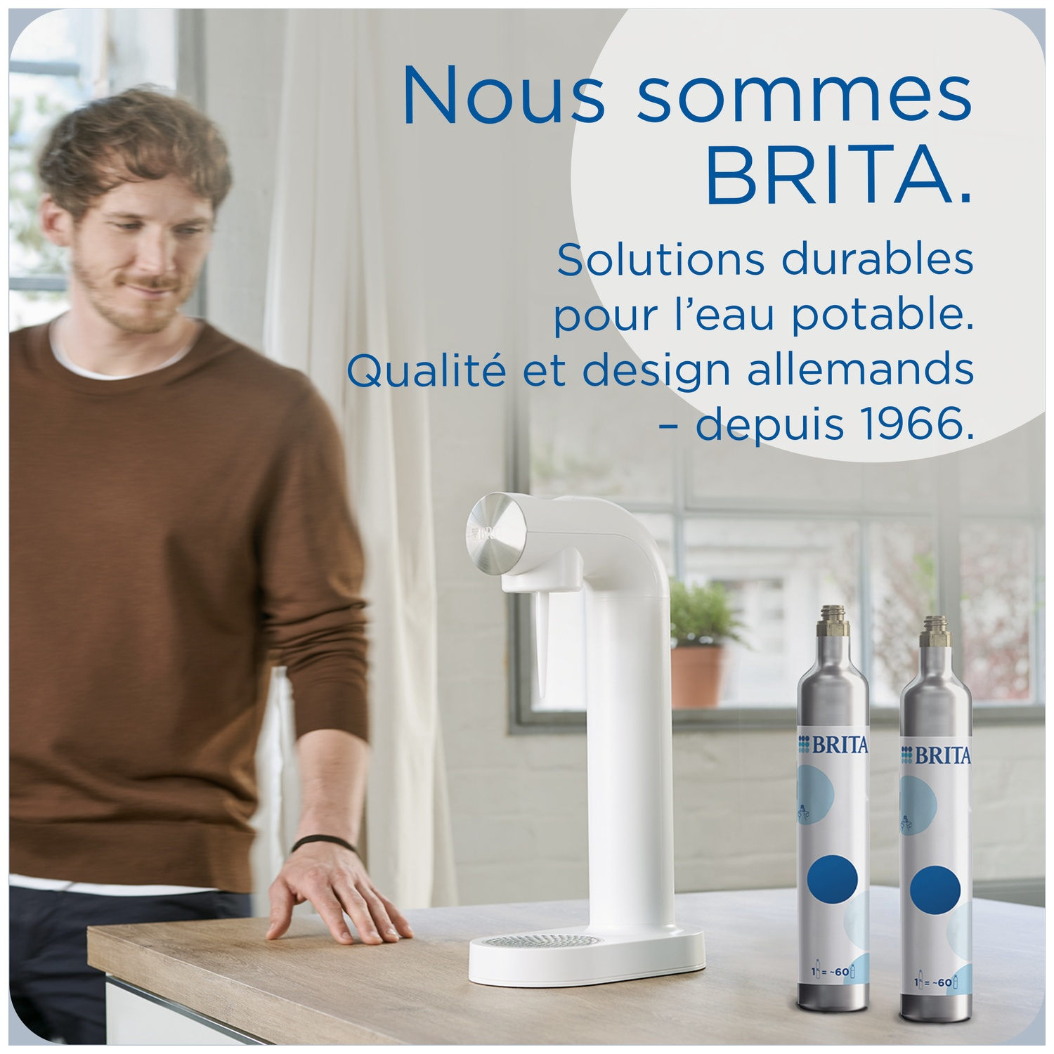 Man stands next to BRITA water dispenser and gas cylinders in a kitchen.