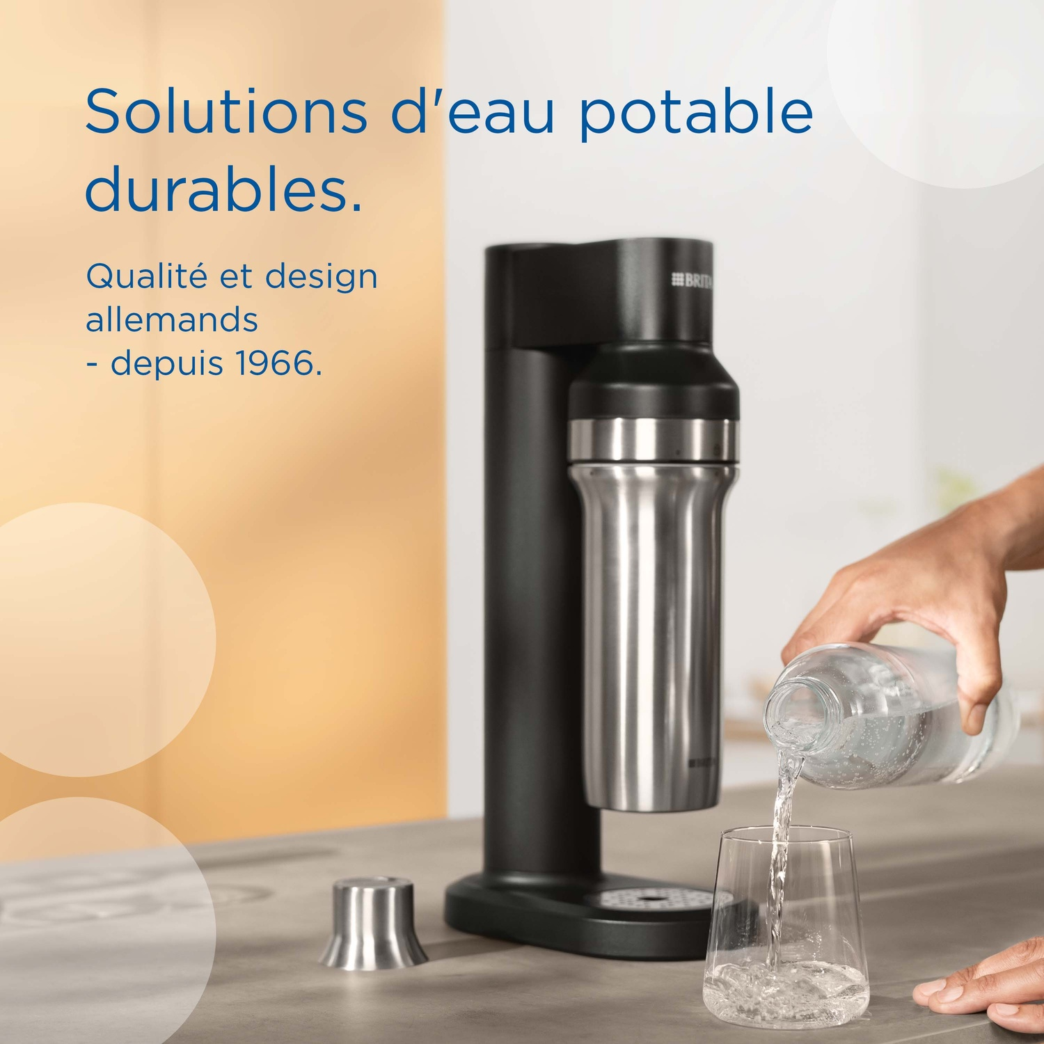 A water carbonator with a silver bottle, and water being poured into a glass next to it.