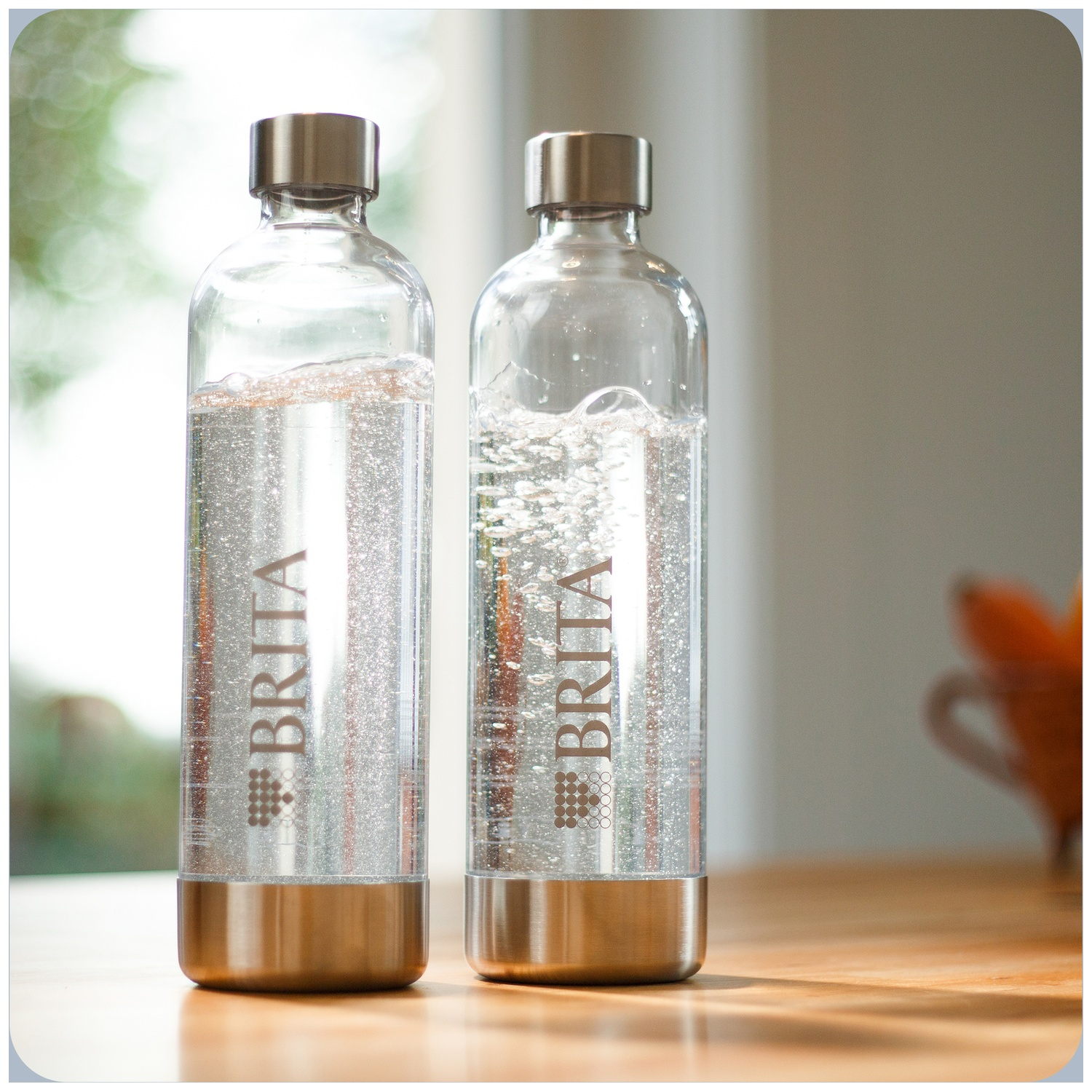 Two glass Brita water bottles with silver caps and bases.