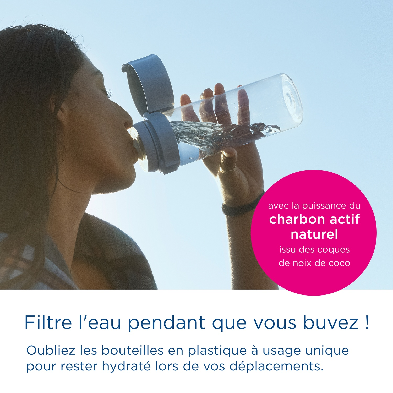 Een vrouw drinkt water uit een doorzichtige fles met grijs deksel.