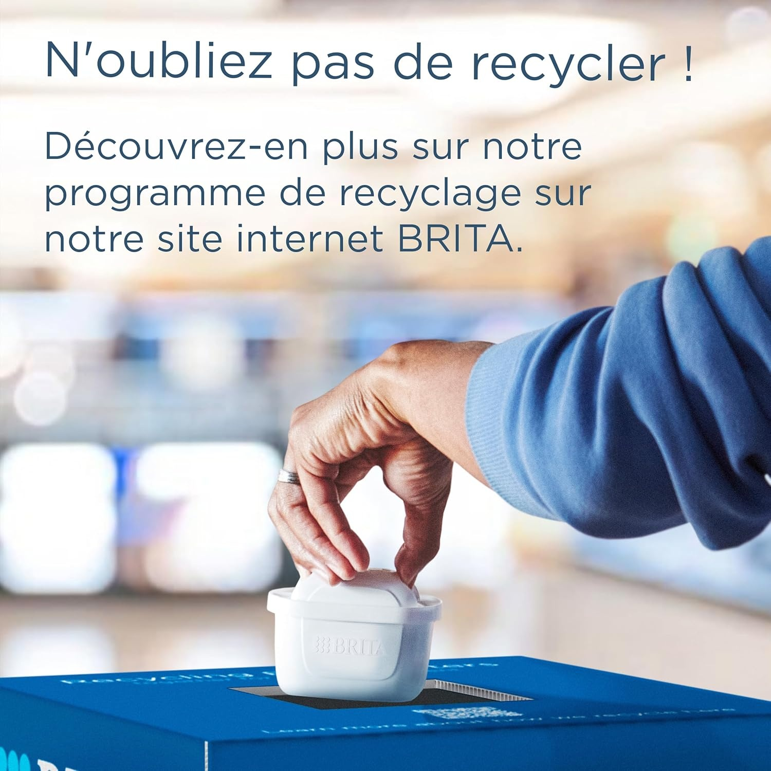 Een hand plaatst een wit Brita-filter in een blauwe inzamelbak.