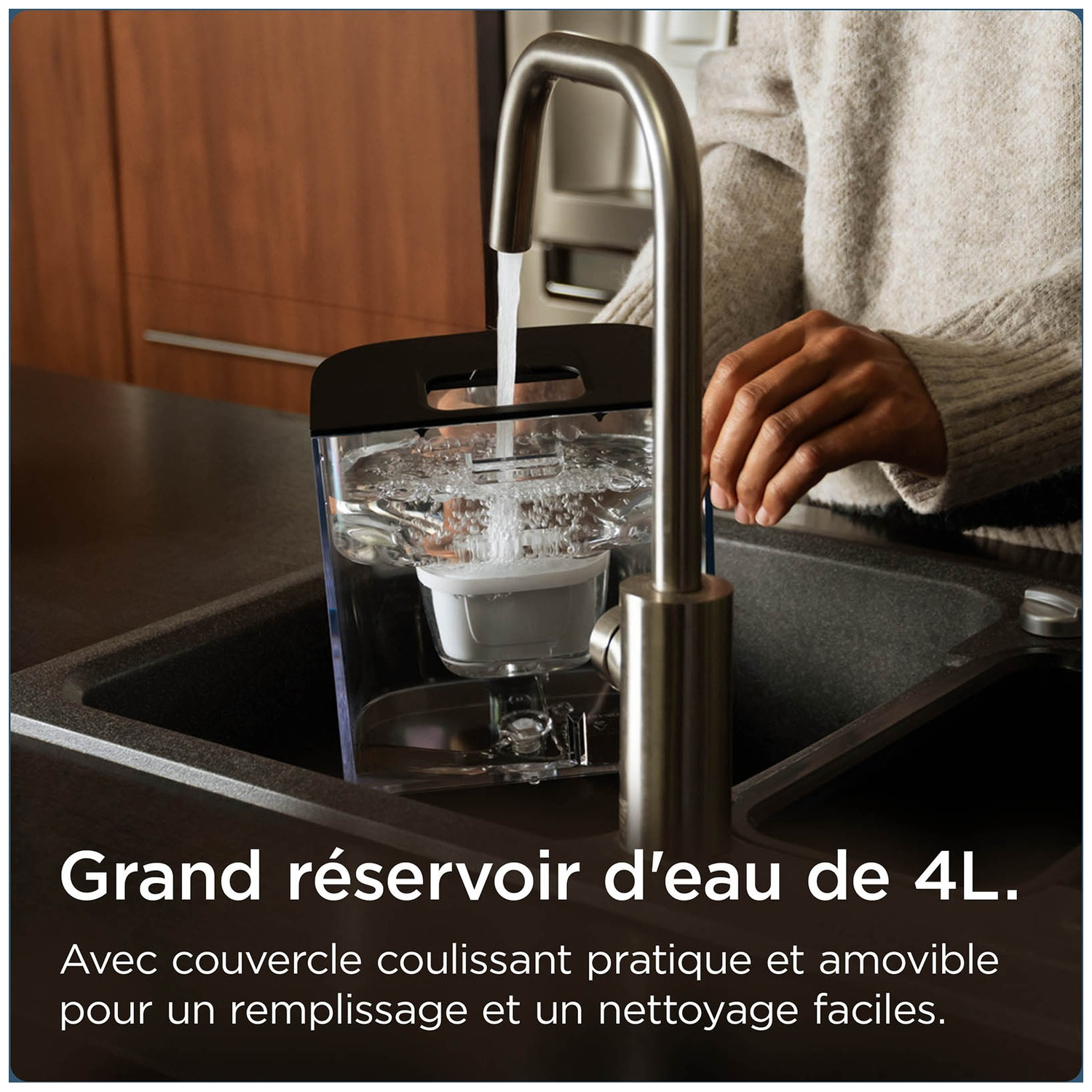A large 4L water tank is filled with water from a faucet in a sink.