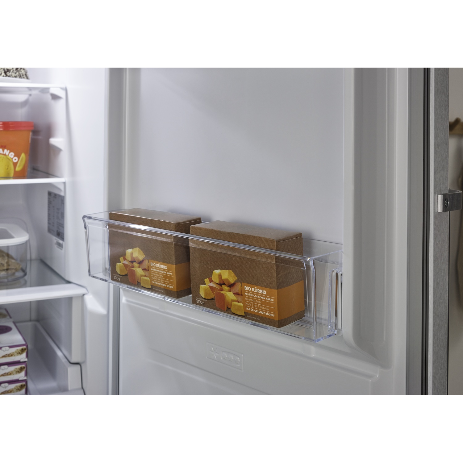 Two brown boxes of pumpkin cubes in a clear refrigerator bin.