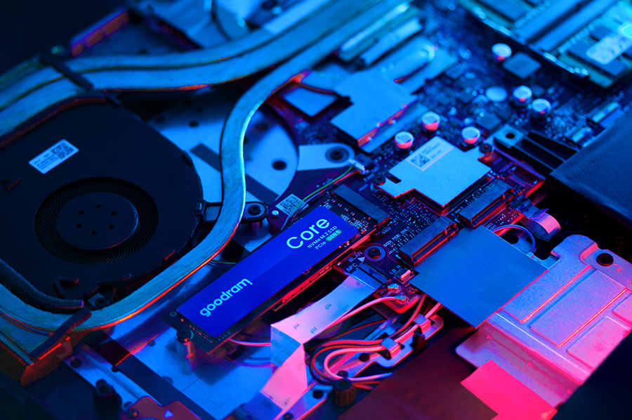 Płyta główna komputera z wentylatorem i niebieskim dyskiem SSD. Czerwone i niebieskie oświetlenie.