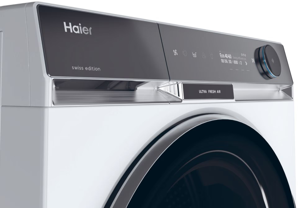Primo piano di una lavatrice Haier bianca con pannello di controllo nero e accenti argentati.