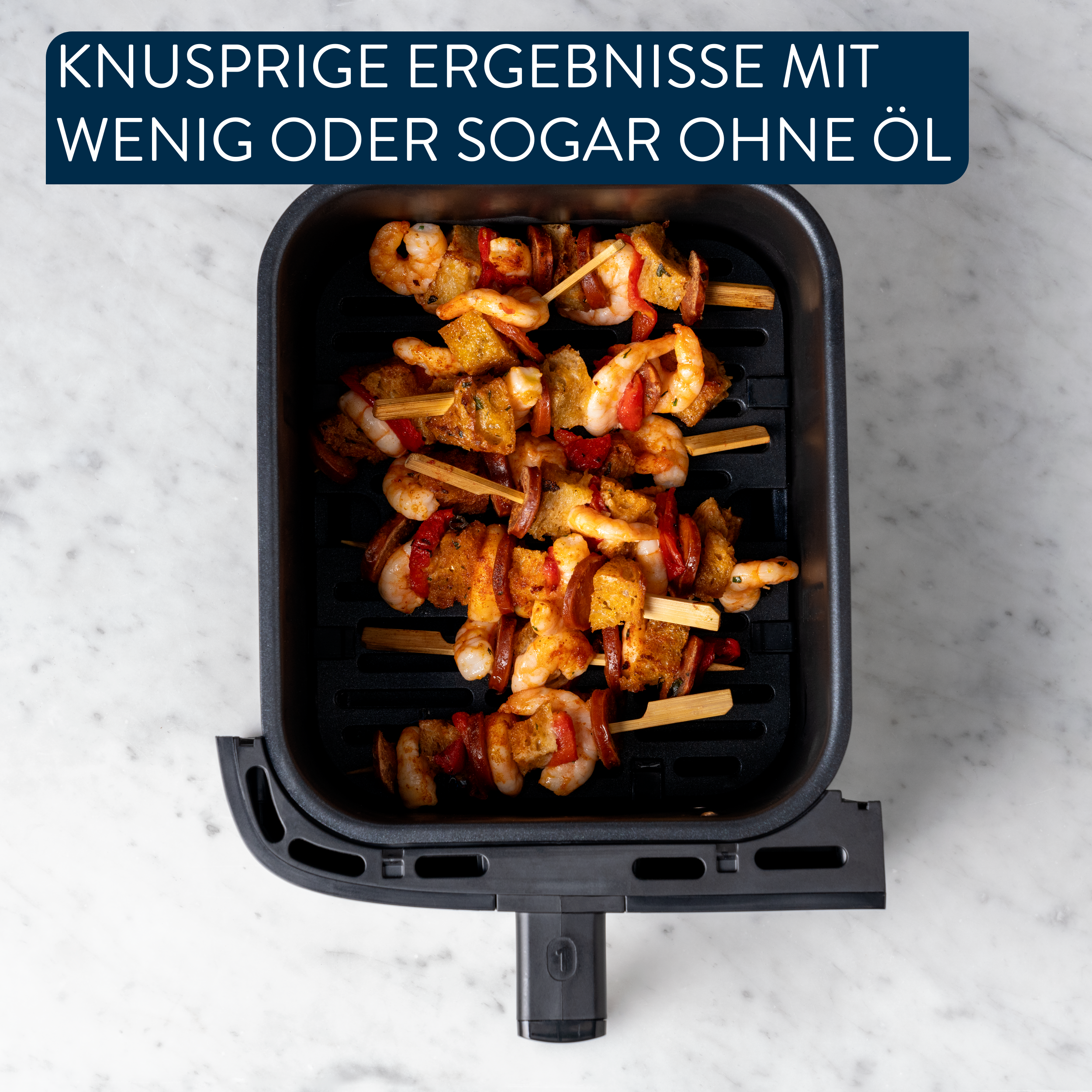 Gegrillte Garnelen- und Brotspieße in einem schwarzen Airfryer-Korb.